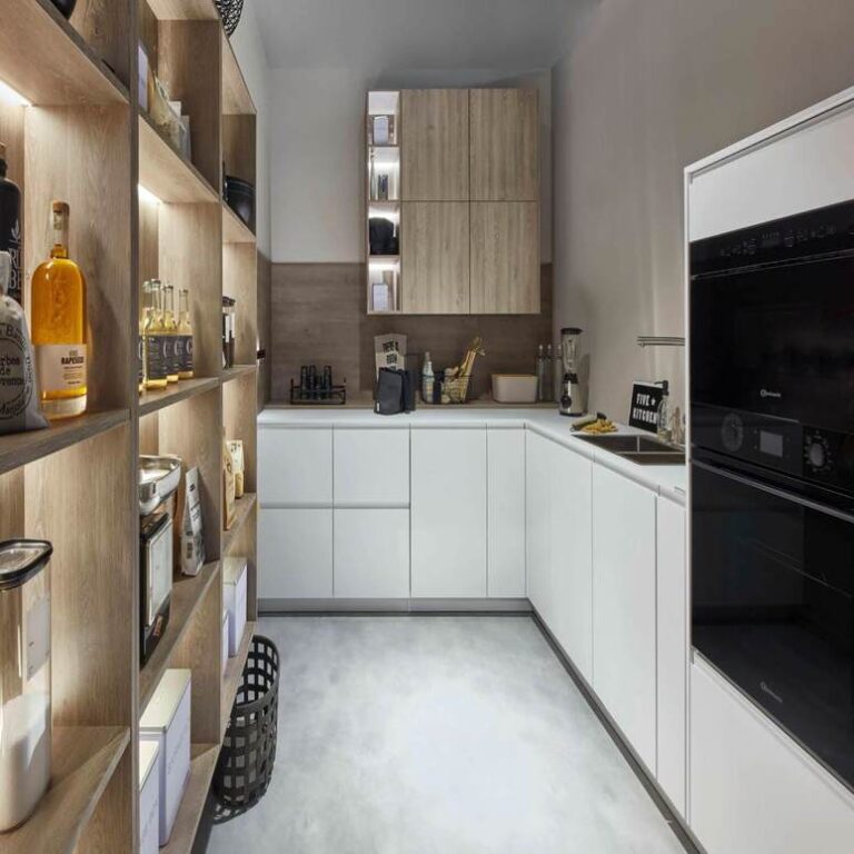Moderne weiße Küche mit Hochschränken, Holzregal und schwarzen Einbaugeräten – Küchenberatung Bielefeld